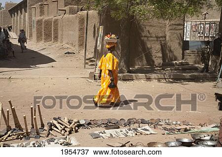 Farming implements for sale with woman walking in the background at the Monday Market in Djenne, Mali View Large Photo Image Stock Photo - Farming implements for sale with woman walking in the background at the Monday Market in Djenne, Mali. Fotosearch