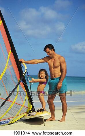 Picture - Father And Daughter Learn Windsurfing On Beach. Fotosearch