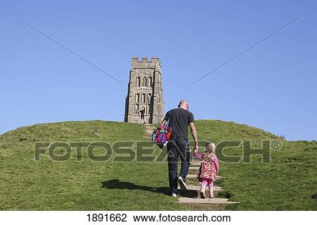 Stock Image - Father And Daughter Walking To St Michael's Tower On Glastonbury Tor. Fotosearch