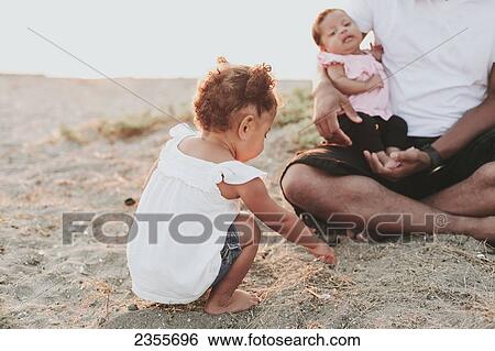 Father And Daughters Relaxing On The Beach; British Columbia, Canada View Large Photo Image Stock Photograph - Father And Daughters Relaxing On The Beach; British Columbia, Canada. Fotosearch