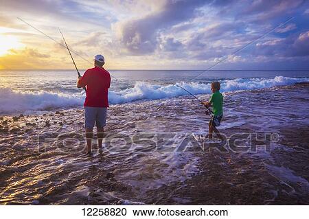 Stock Image - Father and son fishing on Niue Island; Niue. Fotosearch