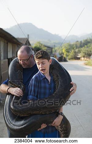 Father and son holding a very large python; Thaton, Chiang Rai, Thailand View Large Photo Image Picture - Father and son holding a very large python; Thaton, Chiang Rai, Thailand. Fotosearch