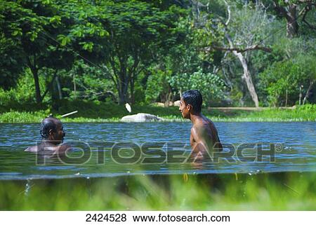 Stock Photo - Father and son swimming in water; Ulpotha, Embogama, Sri Lanka. Fotosearch