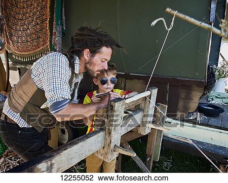 Father and son using a foot powered lathe at a music festival; Dorset, England View Large Photo Image Stock Image - Father and son using a foot powered lathe at a music festival; Dorset, England. Fotosearch