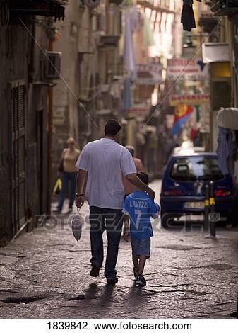Stock Image - Father And Son Walking On Street Of Historic Old Town, Rear View; Naples, Italy. Fotosearch