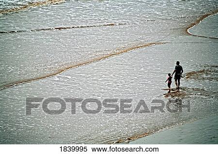 Stock Photography - Father And Son Walking On The Beach, Man Holding Fishing Rod; Sidmouth, Devon, England. Fotosearch