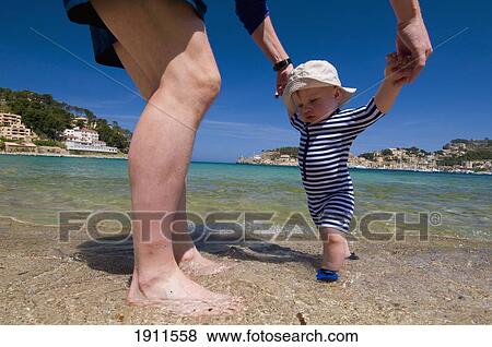 Father Helping Baby Boy (6-11 Months) Walk On Beach, Soller, Majorca, Balearic Islands, Spain View Large Photo Image Stock Photo - Father Helping Baby Boy (6-11 Months) Walk On Beach, Soller, Majorca, Balearic Islands, Spain. Fotosearch