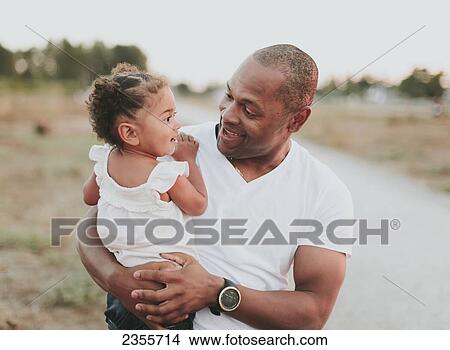 Picture - Father Holding His Daughter On Beach; British Columbia, Canada. Fotosearch