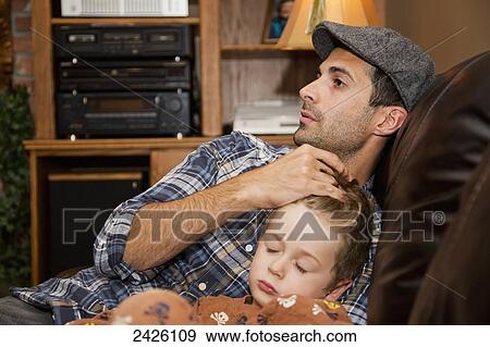 Father stroking his son's head as he falls asleep; Edmonton, Alberta, Canada View Large Photo Image Stock Photo - Father stroking his son's head as he falls asleep; Edmonton, Alberta, Canada. Fotosearch