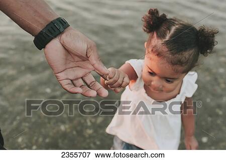 Stock Photo - Father Wading In Water With Daughter; British Columbia, Canada. Fotosearch