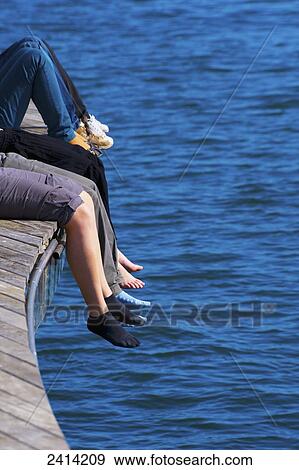 Feet dangling over the edge of a wooden promenade at the water's edge; Barcelona, Spain View Large Photo Image Stock Photo - Feet dangling over the edge of a wooden promenade at the water's edge; Barcelona, Spain. Fotosearch