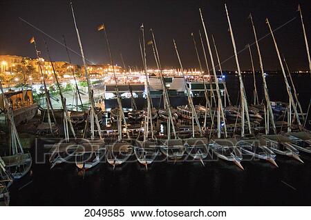 Stock Photography - Feluccas Moored By The Corniche Along The Nile River At Night, Luxor, Qina, Egypt. Fotosearch