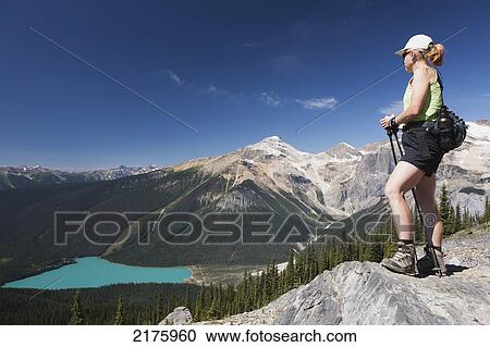 Female Hiker On Top Of Rock Cliff Overlooking Lake Below; Field British Columbia Canada View Large Photo Image Stock Image - Female Hiker On Top Of Rock Cliff Overlooking Lake Below; Field British Columbia Canada. Fotosearch