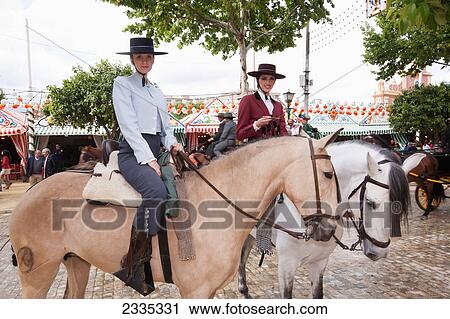 Stock Image - Female Horse Riders Posing During April Feria Festival; Seville, Andalucia, Spain. Fotosearch
