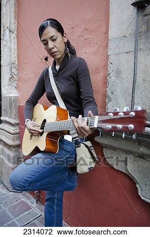 Stock Image - Female musician playing acoustic guitar; Guanajuato, Guanajuato, Mexico. Fotosearch