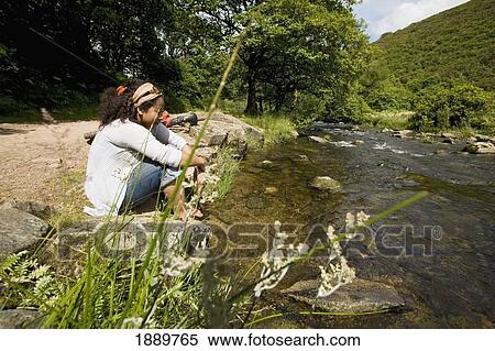 Female Sat On Riverbank Dipping Feet In The Water View Large Photo Image Stock Photography - Female Sat On Riverbank Dipping Feet In The Water. Fotosearch