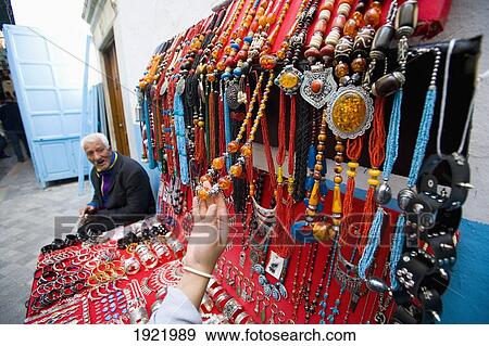 Stock Photo - Female Tourist At Jewellery Stall. Fotosearch