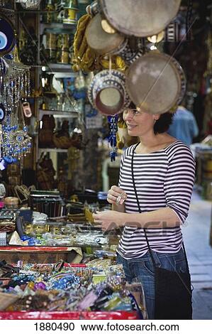 Stock Image - Female Tourist Buying Souvenirs On Souk. Fotosearch