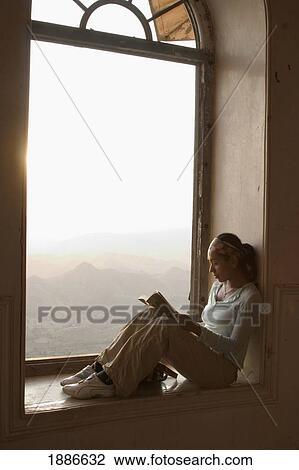 Stock Image - Female Traveller Reading In Window. Fotosearch