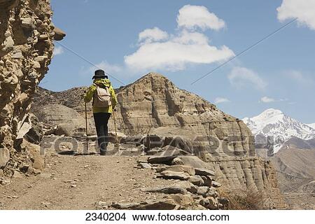 Picture - Female Trekker Walking Towards Shyangmochen La; Gyakar, Upper Mustang Valley, Nepal. Fotosearch