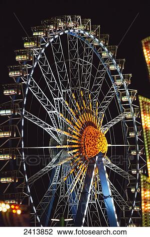 Stock Image - Ferris wheel illuminated at nighttime; Munich, Germany. Fotosearch