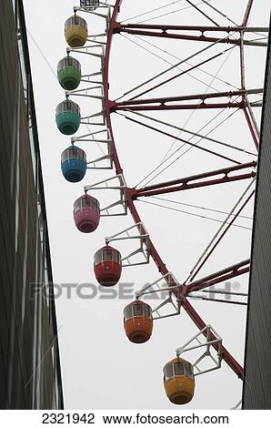 Stock Image - Ferris wheel with colorful passenger cars; Tokyo, Japan. Fotosearch