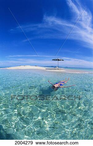 Fiji, Blonde Woman Floats Calm Turquoise Ocean Off Private Sand Island With Beach Chairs And Umbrella, Wide Angle Blue Sky View Large Photo Image Stock Photo - Fiji, Blonde Woman Floats Calm Turquoise Ocean Off Private Sand Island With Beach Chairs And Umbrella, Wide Angle Blue Sky. Fotosearch