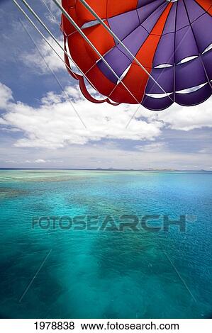 Stock Photo - Fiji, Colorful parachute over reef and Pacific Ocean; Mamanuca Islands. Fotosearch
