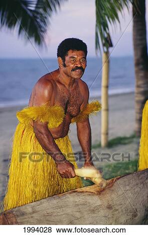Stock Photo - Fiji, Local Man In Grass Skirt Hitting Sticks.. Fotosearch