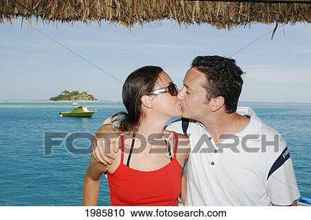 Fiji, Mamanuca Islands, Malolo Island, Young Tourist Couple Kissing, Wadigi Island In Background. For Editorial Use Only. View Large Photo Image Stock Image - Fiji, Mamanuca Islands, Malolo Island, Young Tourist Couple Kissing, Wadigi Island In Background. For Editorial Use Only.. Fotosearch