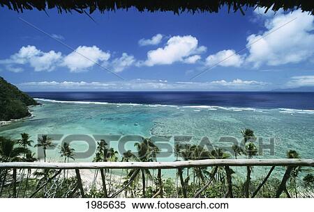 Stock Photography - Fiji, Ocean's view framed by railing and thatched roof; Wakaya Island, Private home. Fotosearch