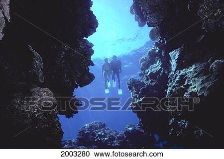 Stock Image - Fiji, Qamea Island, Grouper Cave, Divers Enter Coral Cave. Fotosearch
