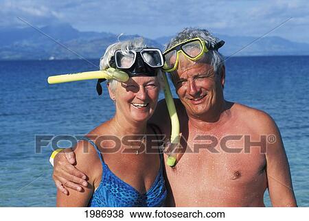 Fiji, Smiling Senior Couple Wearing Snorkel Gear On Beach In Bright Sunlight. View Large Photo Image Stock Photo - Fiji, Smiling Senior Couple Wearing Snorkel Gear On Beach In Bright Sunlight.. Fotosearch