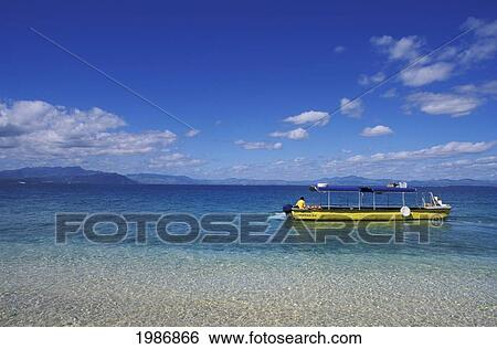 Stock Photograph - Fiji, South Sea Island, Local Person In Yellow Boat, Crystal Clear Ocean Water.. Fotosearch