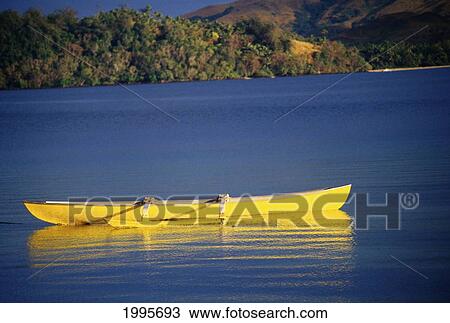 Stock Image - Fiji, Turtle Island, Empty Yellow Canoe Floating In The Water. Fotosearch