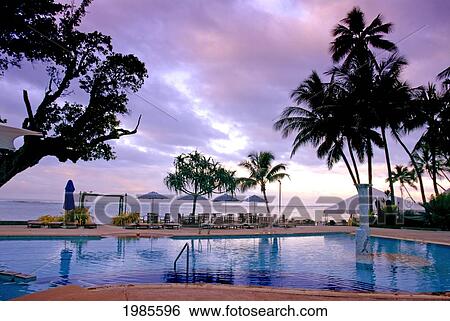 Stock Photograph - Fiji, Viti Levu, Coral Coast, Hidewaway Resort, Early Morning Light, Pink Clouds Over Ocean And Resort Swimming Pool.. Fotosearch
