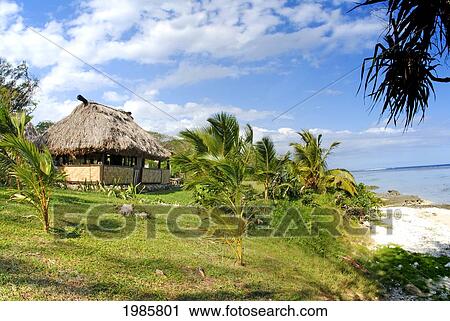 Stock Image - Fiji, Viti Levu, Coral Coast, Traditional fijian bure next to ocean; Cocomo Beach. Fotosearch