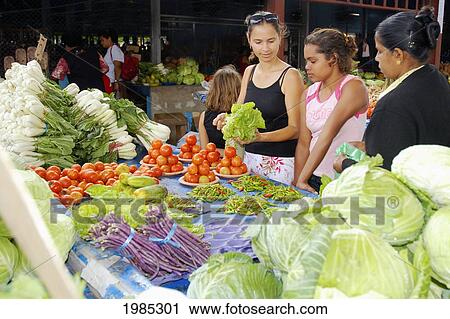 Stock Image - Fiji, Viti Levu, Sigatoka, Female Tourist Buying Produce At A Market. For Editorial Use Only.. Fotosearch