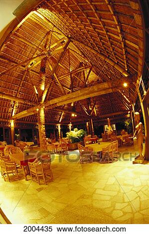 Stock Photography - Fiji, Wakaya Island, Interior Of Main Bure Of Wakaya Club Golden Lighting, Restaurant Tables And Chairs Traditional Fijian Building With Modern. Fotosearch