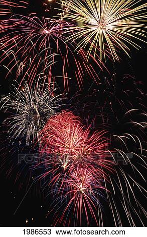 Stock Image - Fireworks Display, Red White And Blue Bursts In Black Sky.. Fotosearch