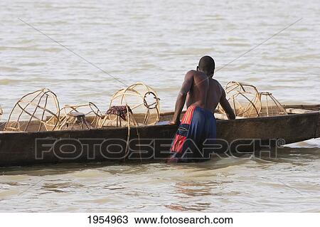 Fisherman and his nets on a boat in Lake Debo, formed by the seasonal flooding of the Niger River, Mali View Large Photo Image Stock Image - Fisherman and his nets on a boat in Lake Debo, formed by the seasonal flooding of the Niger River, Mali. Fotosearch