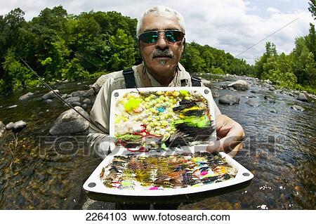 Stock Image - Fisherman Holding Up Various Lures; Agawam Massachusetts Usa. Fotosearch