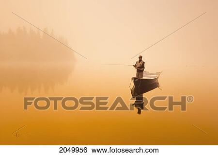 Stock Photograph - Fisherman In Mist At Sunrise, Rimouski Lake, Rimouski Wildlife Reserve, Bas-Saint-Laurent Region, Quebec. Fotosearch