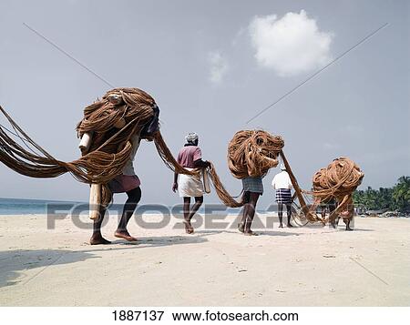 Stock Photo - Fishermen Carrying Nets On Beach. Fotosearch