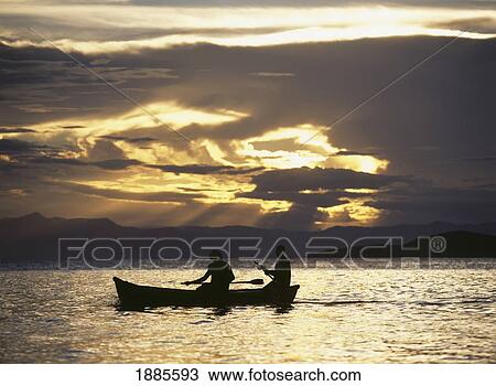 Stock Image - Fishermen Going Past The Island Of Domwe At Dusk. Fotosearch