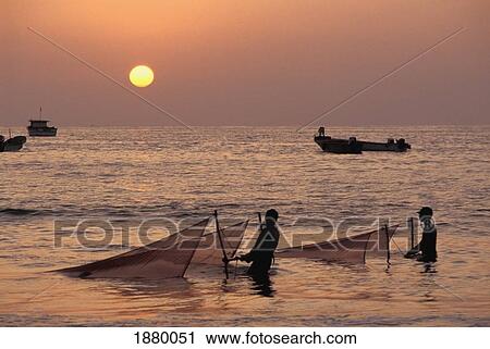 Stock Image - Fishermen Holding Nets In Sea At Sunset. Fotosearch