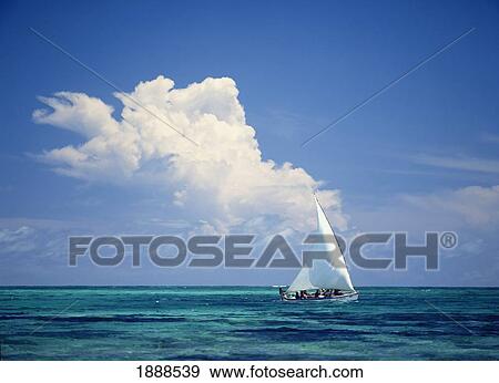 Stock Photo - Fishermen In Dhow Sailing In Shallow Water In Front Of Large Thunder Storm Cloud. Fotosearch