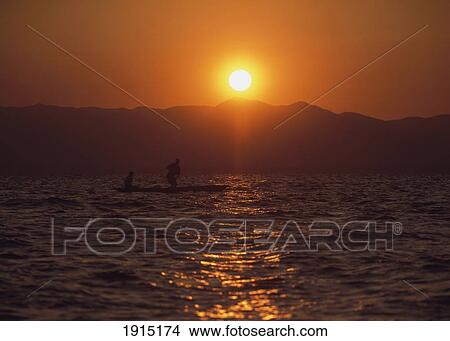 Picture - Fishermen In Dugout Canoe At Dawn. Fotosearch