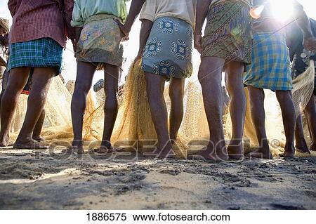 Stock Photography - Fishermen In Traditional Dress Holding Nets, Low Angle View. Fotosearch