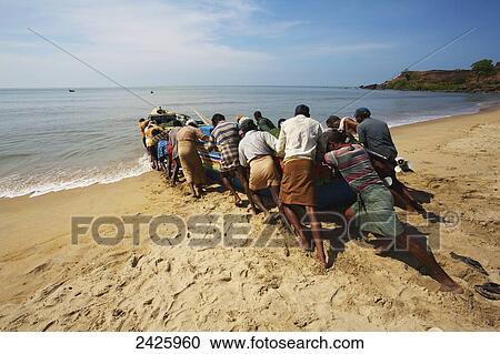Stock Image - Fishermen on Bekal beach; Northern Kerala, India. Fotosearch